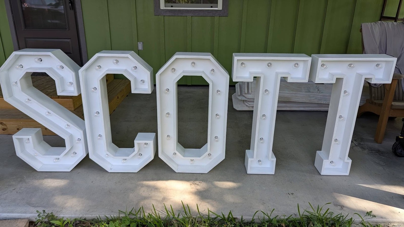 Marquee letters spelling a couple's name on a porch for a wedding celebration